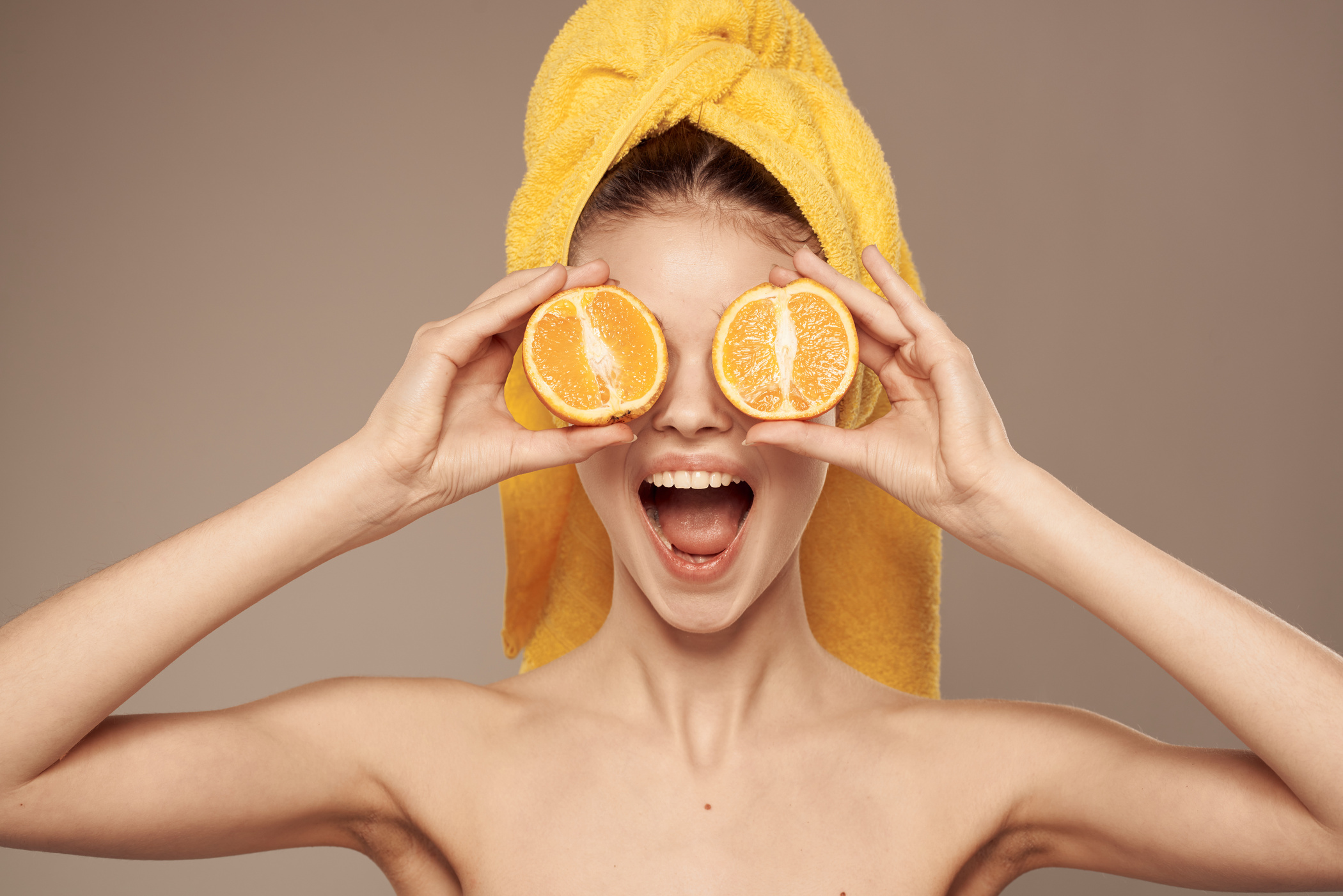 Cheerful Woman Holding Oranges near Her Eyes Skin Care